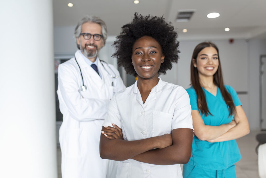 multiethnic-group-three-doctors-nurses-standing-hospital-corridor-wearing-scrubs-coats-team-healthcare-workers-are-staring-camera-smiling-1024x683 Conheça as profissões em alta nos próximos anos.